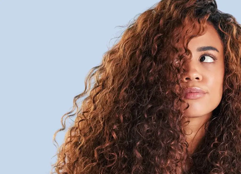 mujer con cabello rizado definido y cuidado sin frizz
